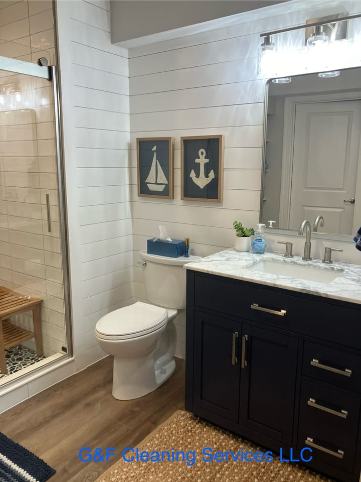A bathroom vanity and toilet cleaned, mirror and marble polished