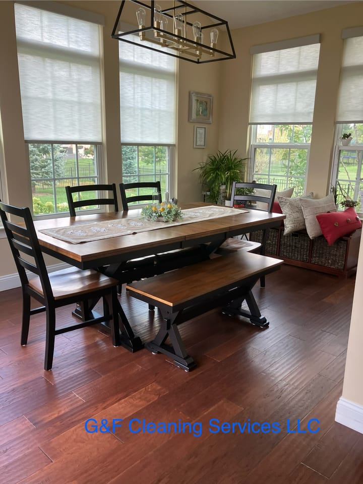 A bright dining room with large windows, table and floor cleaned