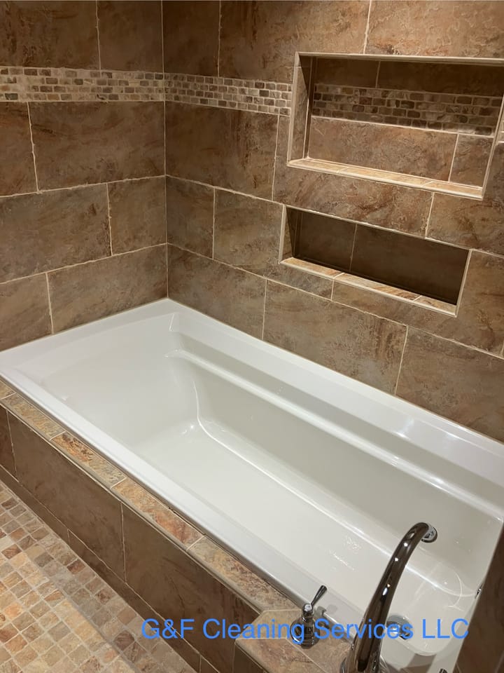 A tiled tub surround with recessed shelves, grout and tub cleaned
