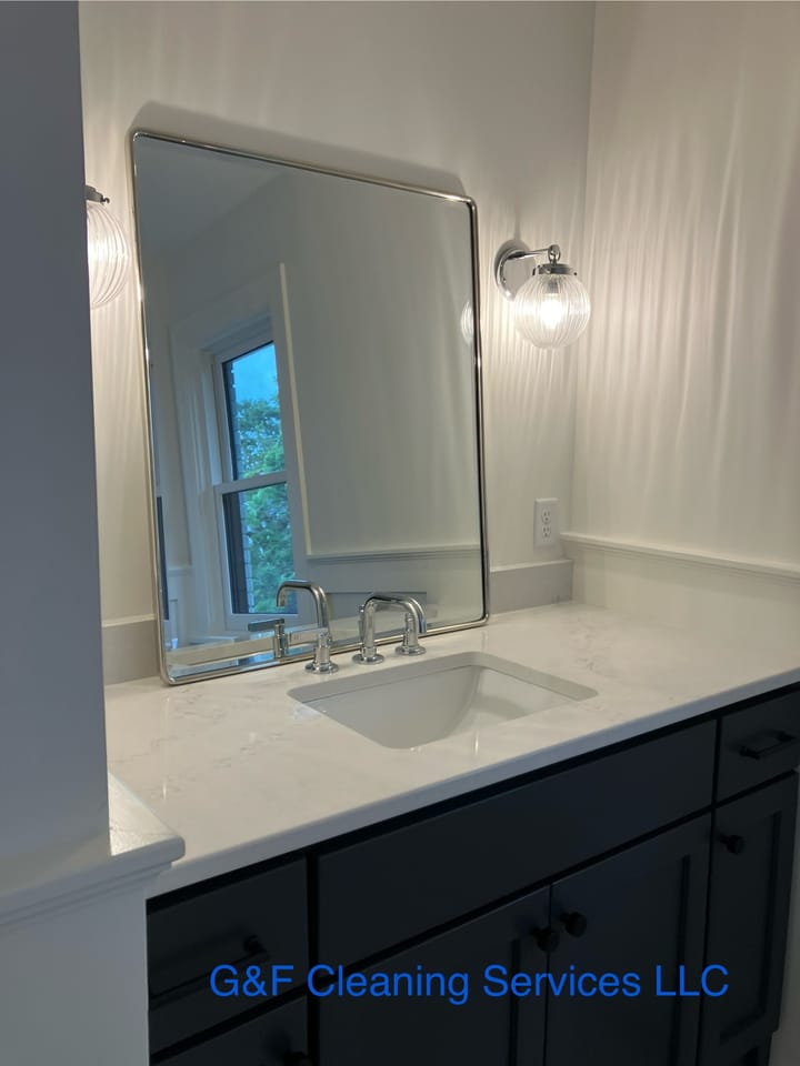 A bathroom vanity with a large mirror, counter and basin polished
